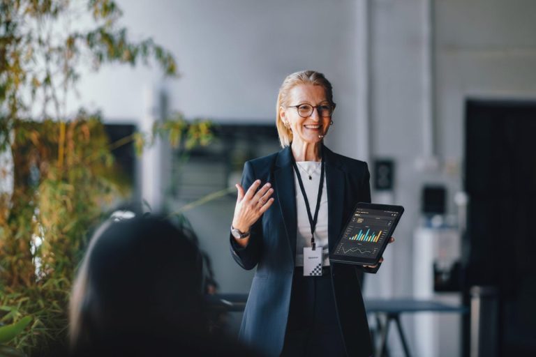 Professional business leader presenting data insights on a tablet during a corporate meeting, demonstrating thought leadership and strategic decision-making